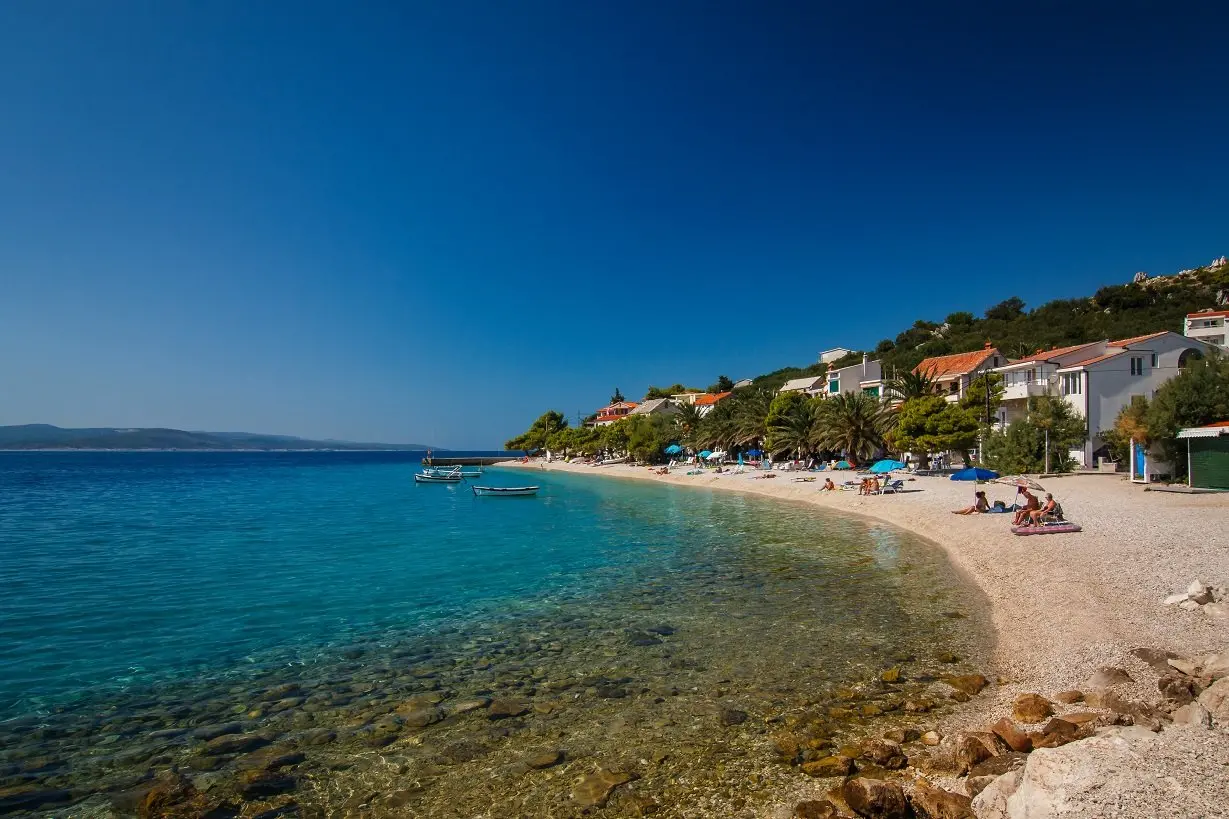 Strand in Bratus mit klarem Meer und Palmen