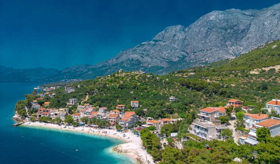 Luftaufnahme vom Strand in Bratus, den Häusern und dem Biokovo-Gebirge